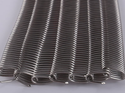 Details about dense wire mesh belt and its edge, it is lying on the white background.
