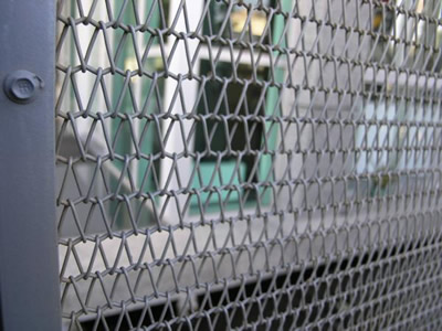 A part of gray wire mesh belt, there is a house inside it.