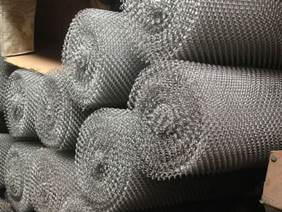 Several metal coil drapery rolls pile up together.