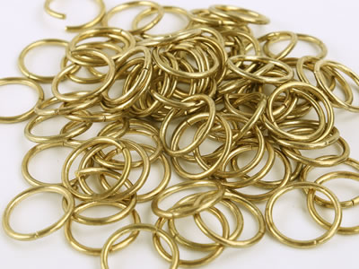 A number of golden single rings of chainmail curtain on the white background.