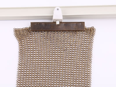 Golden chainmail curtain is fixed on the H track with metal clip.