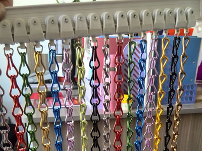 Chain link curtain with various colors is hanging on the H track.