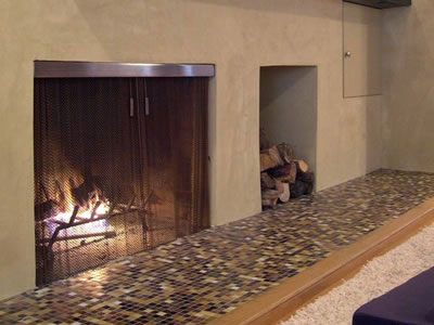 Metal coil drapery as fireplace mesh curtain, and some woods are burning in the fireplace.