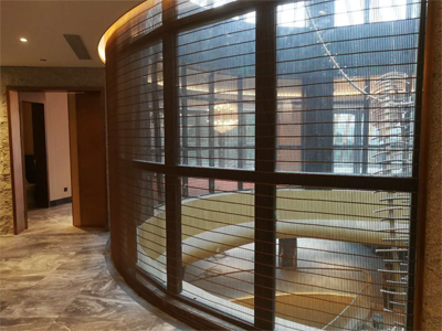 Woven wire mesh is hanging beside the window and wooden fence.
